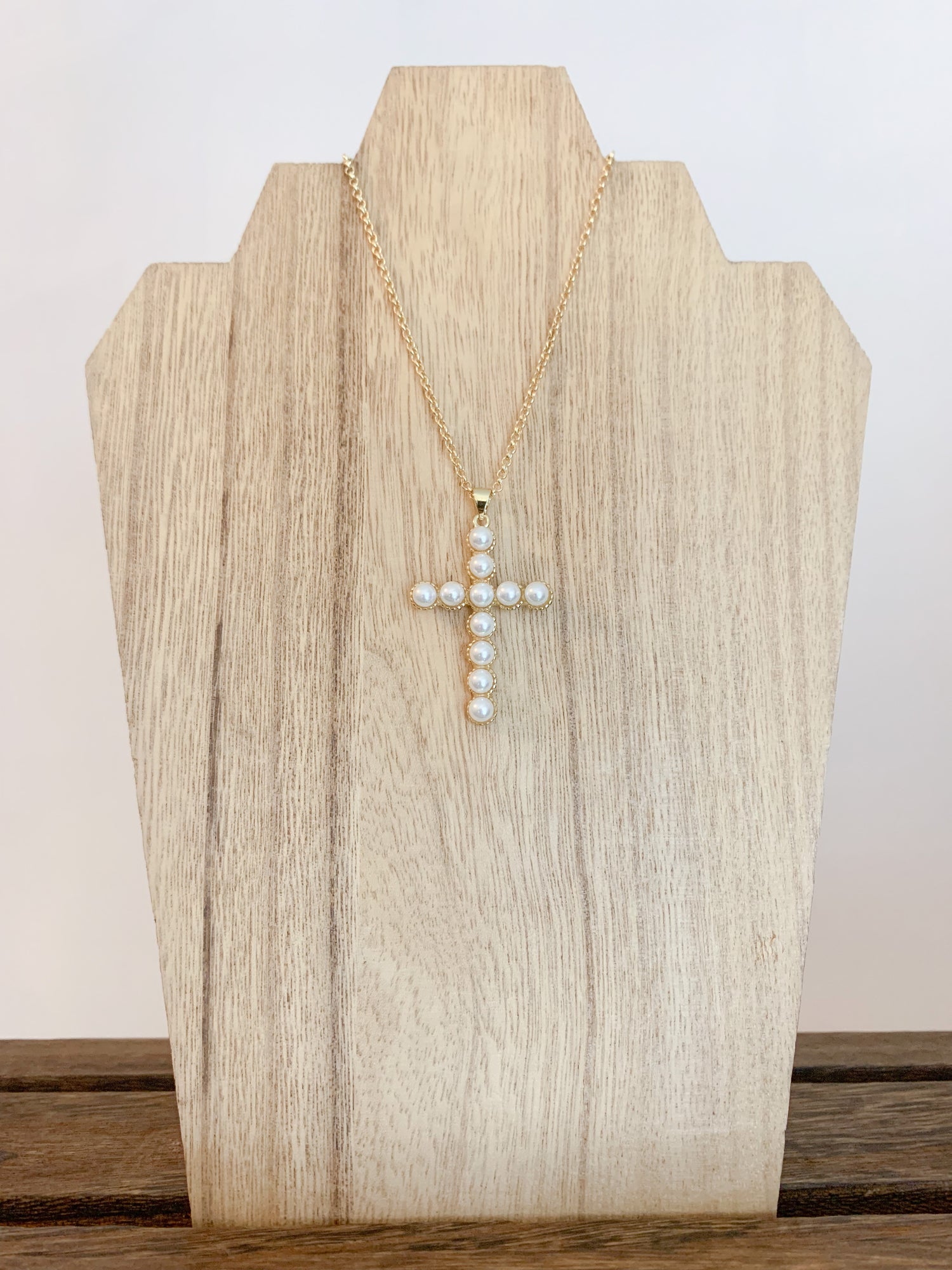 18k gold plated pearl cross necklace on a white background, with the cross centerpiece in focus. A beautiful and elegant jewelry piece to add to your collection.