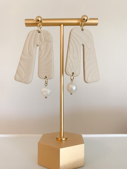 A pair of handcrafted polymer clay earrings featuring 18K gold plated earring posts and a mini pearl