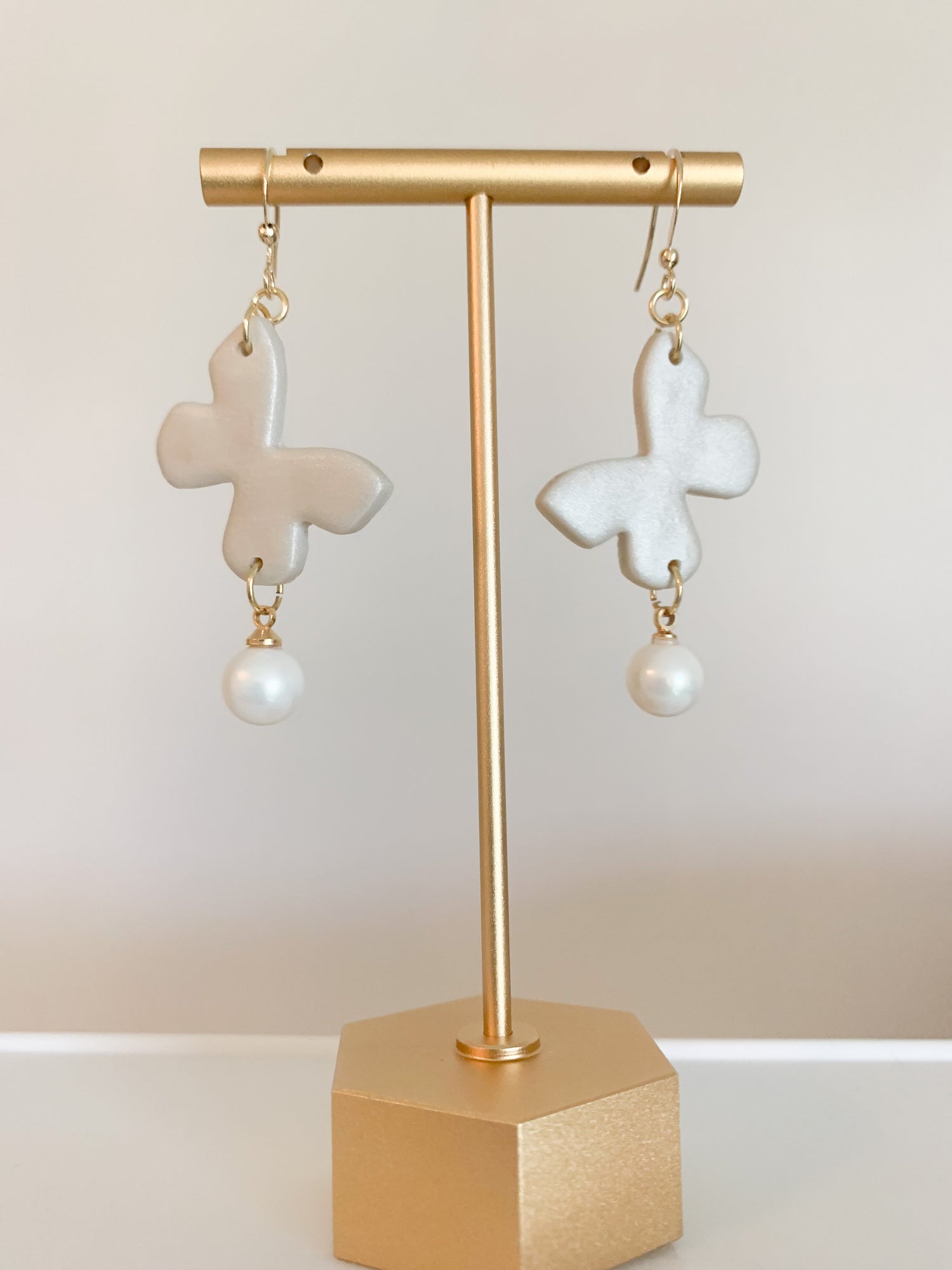 A pair of handcrafted polymer clay earrings featuring 18K gold plated earring posts and a mini pearl