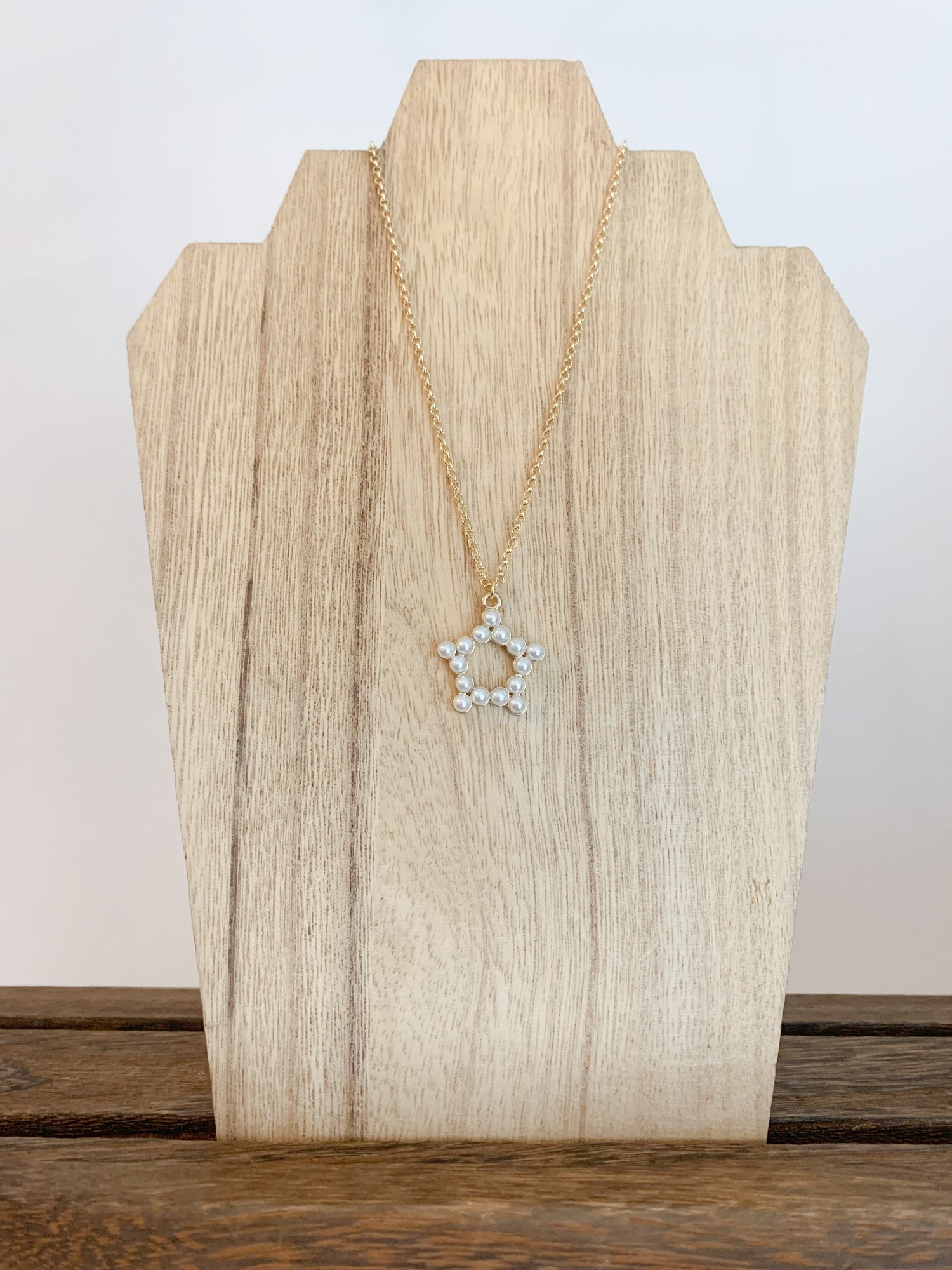18k gold plated pearl star necklace with the star centerpiece in focus. A beautiful and elegant jewelry piece to add to your collection.