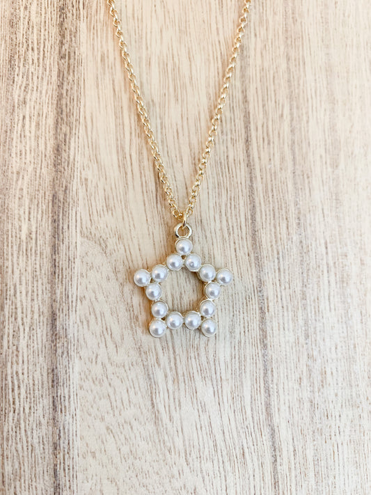 18k gold plated pearl star necklace with the star centerpiece in focus. A beautiful and elegant jewelry piece to add to your collection.