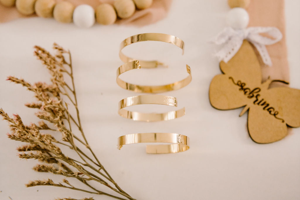 A close up of a trio of gold filled adjustable bracelets.