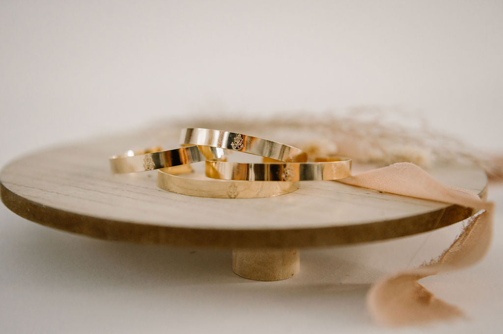 A close up of a trio of gold filled adjustable bracelets.